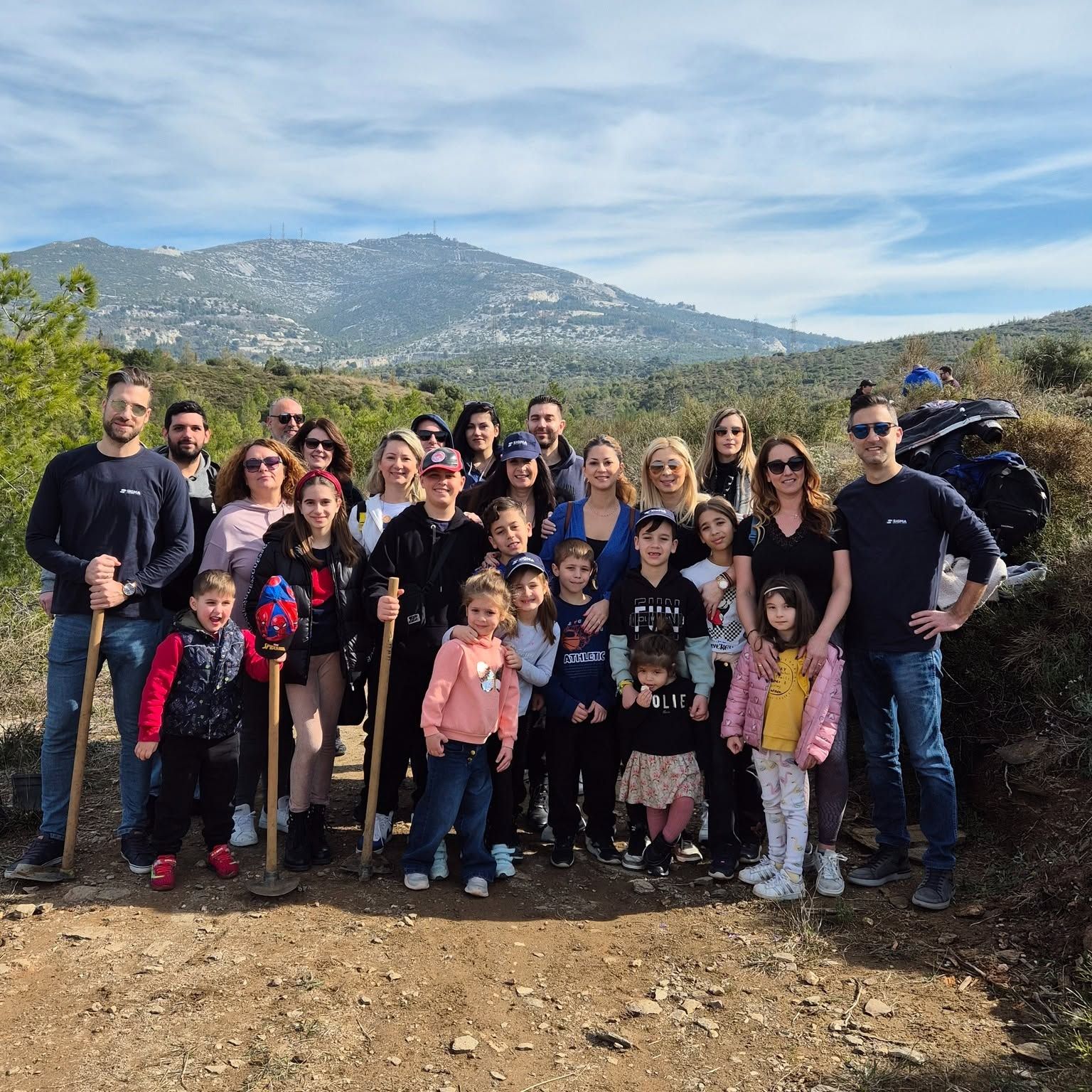 Empleados de Sigma y sus hijos en una plantación de árboles en Penteli