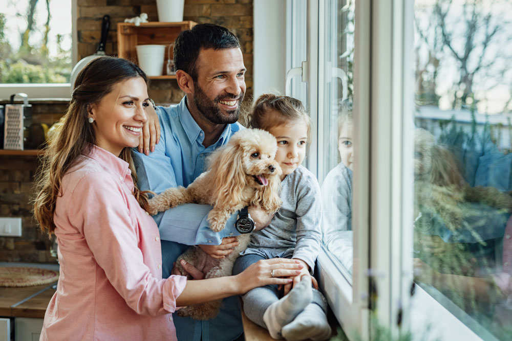 young-happy-family-their-dg-relaxing-by-window-home